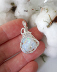 Sterling silver opal pendant in hand for size reference, handcrafted by Designs by Nature Gems.