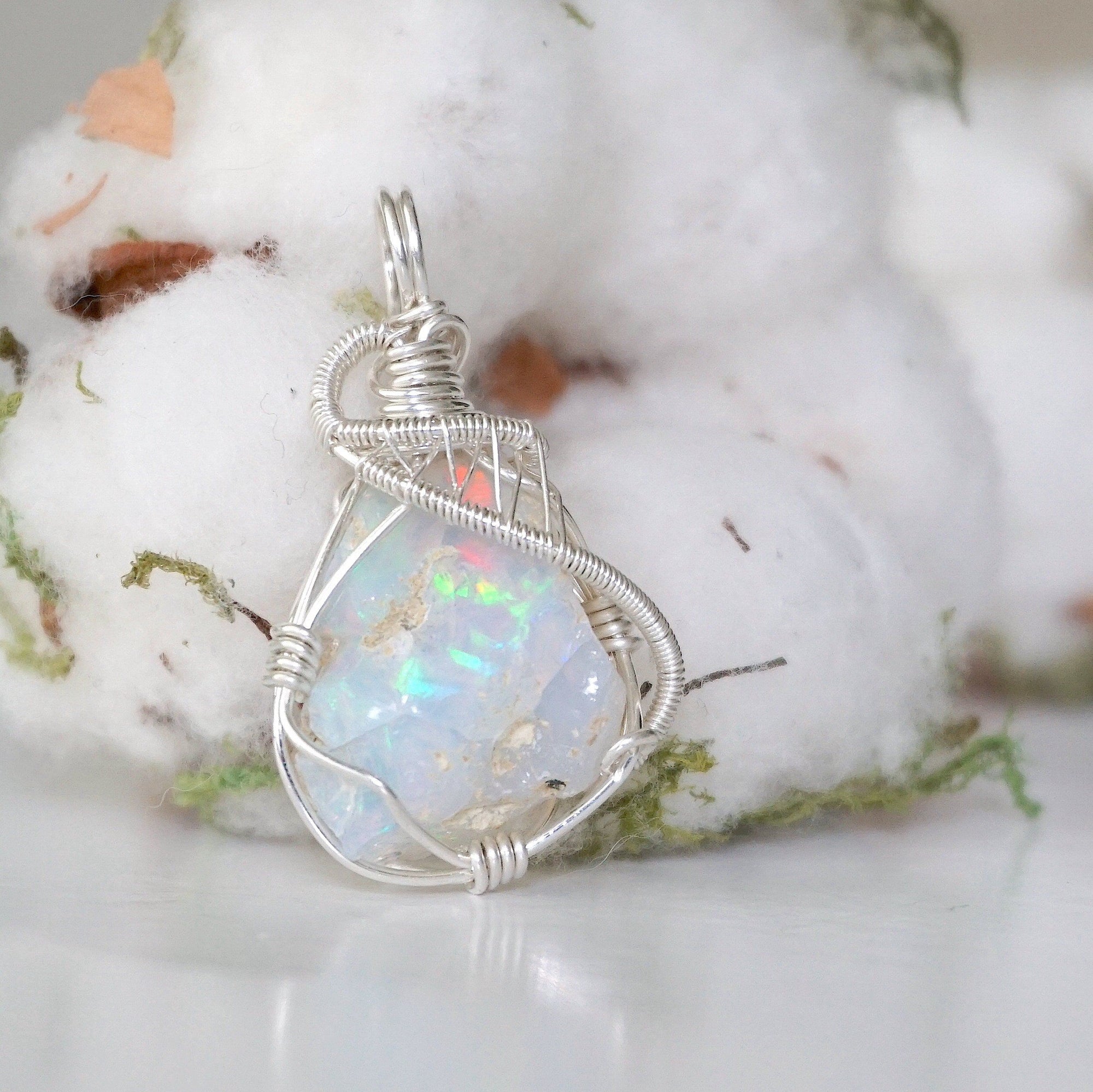 Right side angle detail of sterling silver opal pendant, wire wrapped by Designs by Nature Gems.