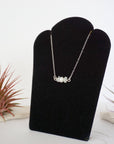 Left angle view of rainbow moonstone and pearl bar necklace in 925 sterling silver on jewelry display