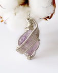 Detailed front view of raw amethyst pendant, natural amethyst crystal wrapped in sterling silver artisan wire