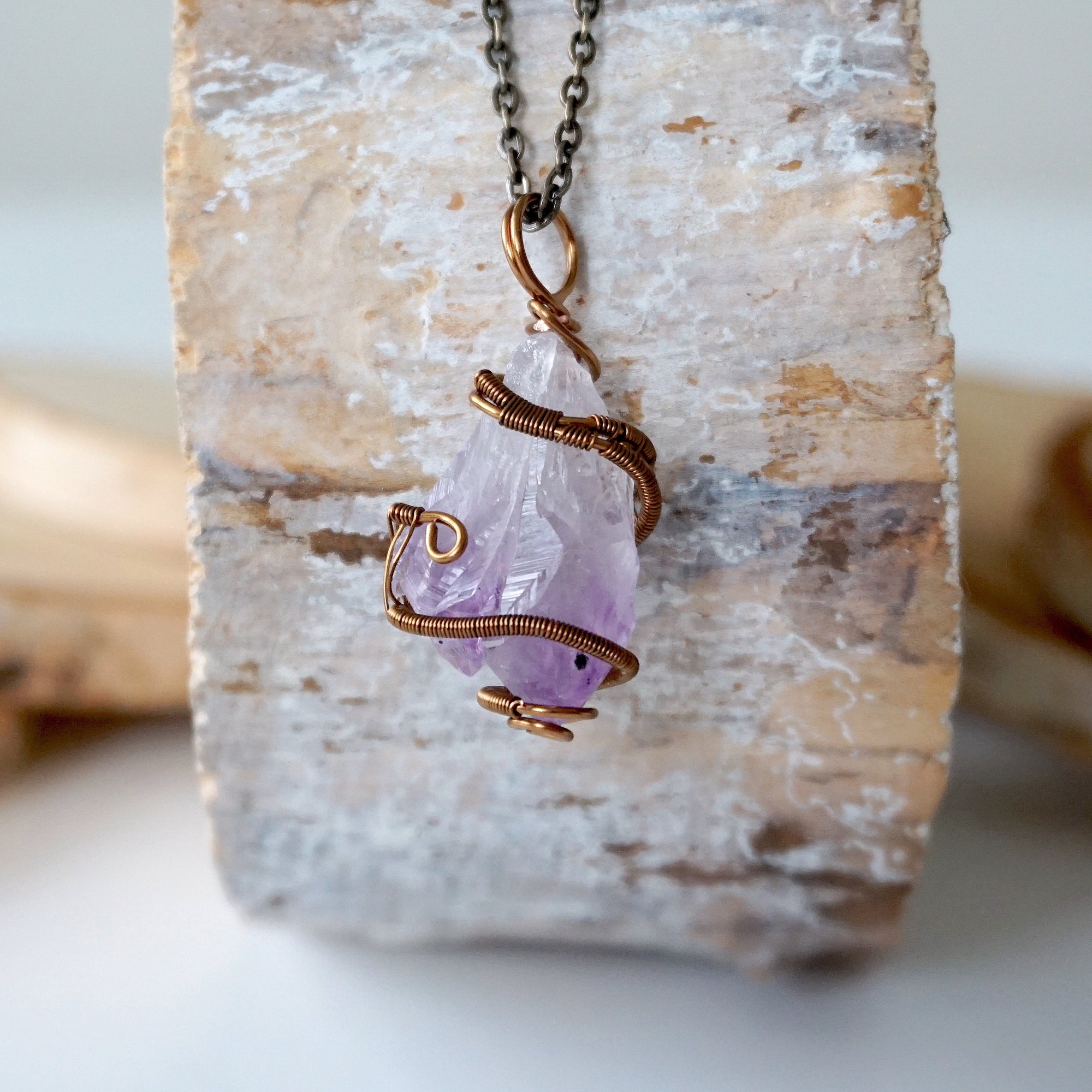 Back view detail of raw amethyst point pendant necklace with detailed antique bronze copper wire wrap on antique bronze chain