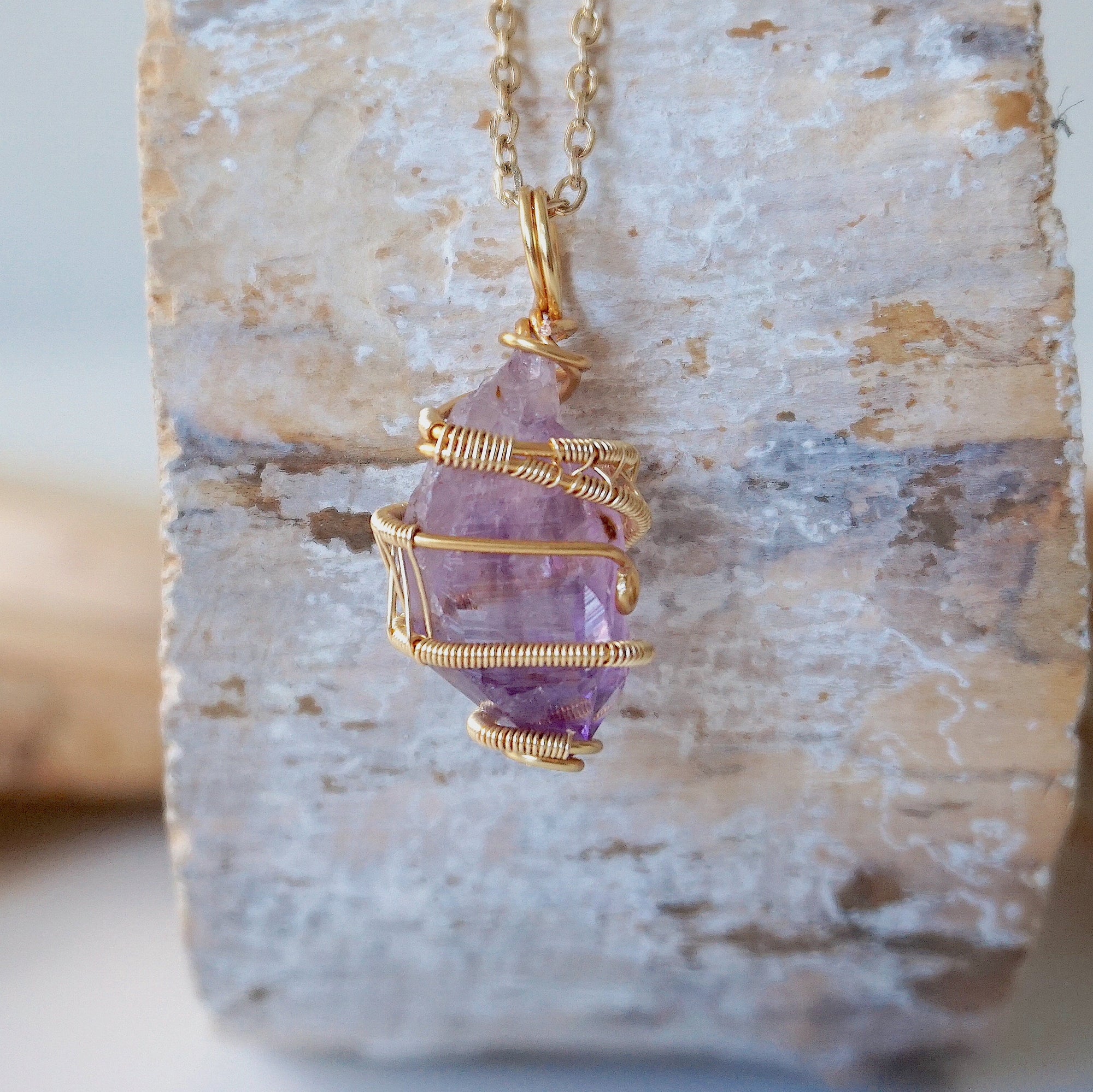 Back view detail of raw amethyst point pendant necklace with detailed gold plated copper wire wrap on gold plated brass chain