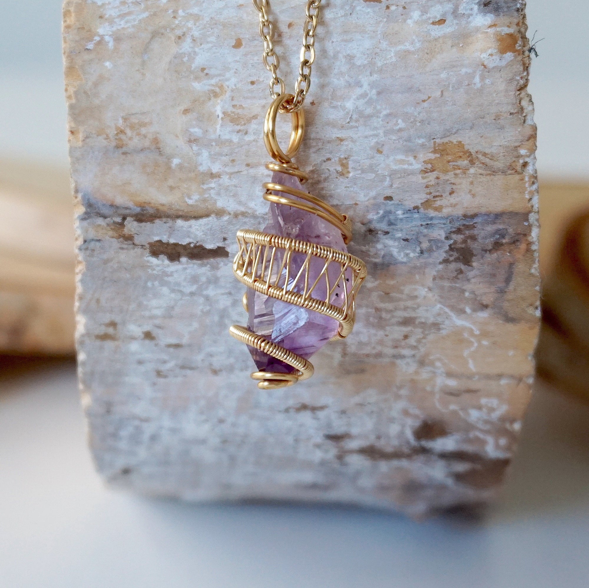 Front view of raw amethyst point necklace with detailed gold plated copper wire wrap on gold plated brass chain