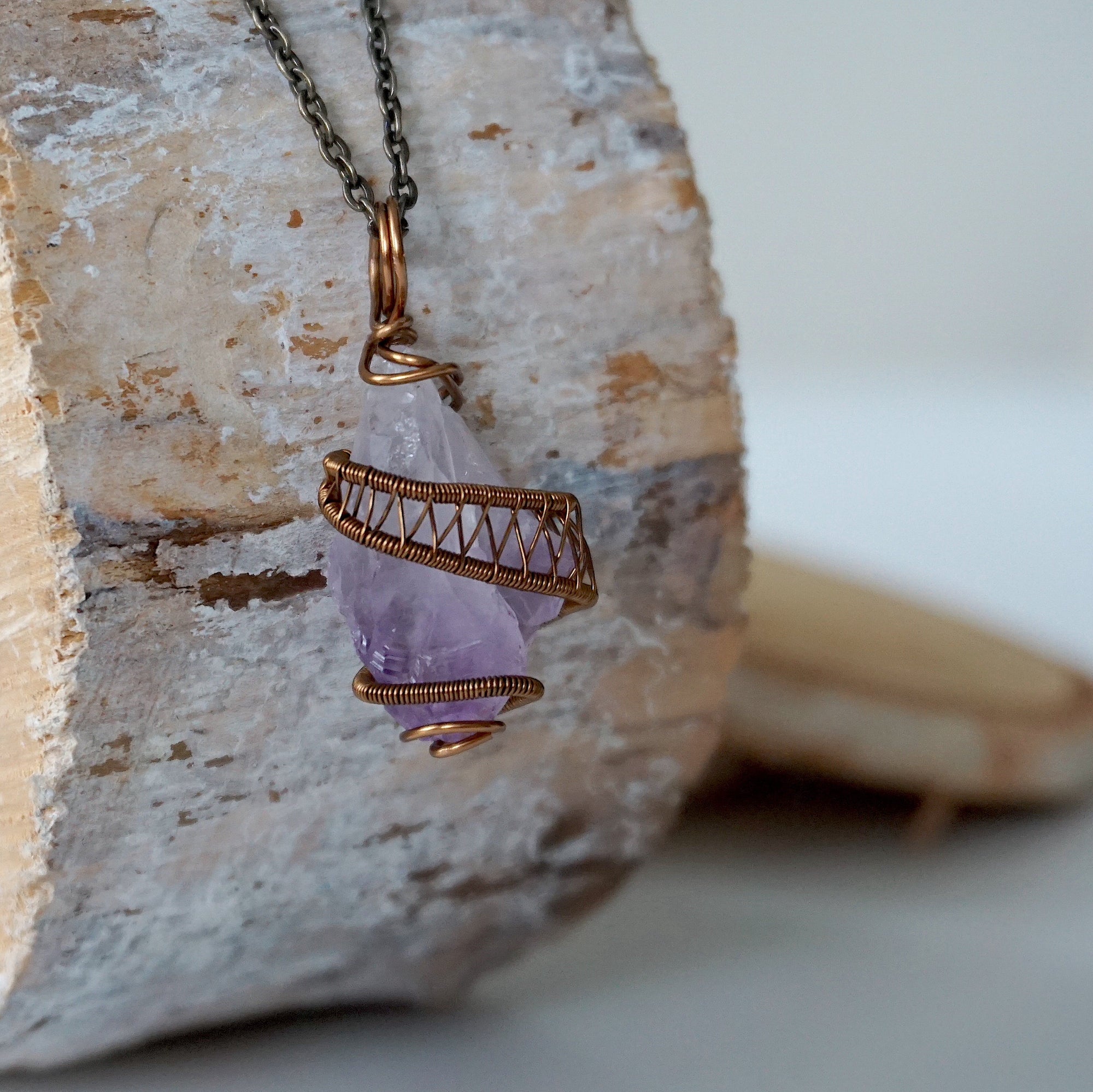 Right side detail of raw amethyst point pendant with intricate antique bronze copper wire wrapping on antique bronze chain