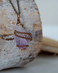 Right side detail of raw amethyst point pendant with intricate antique bronze copper wire wrapping on antique bronze chain