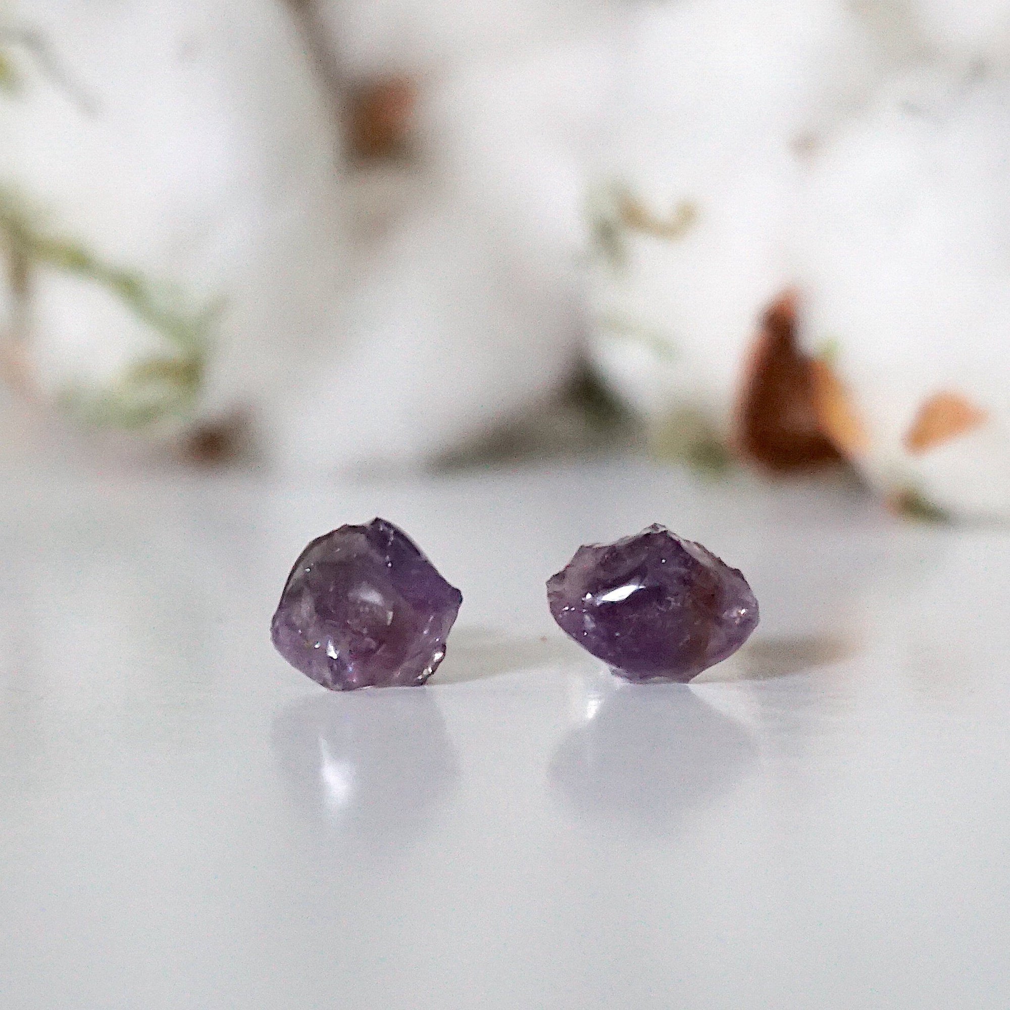 Detailed front view of raw amethyst stud earrings, unpolished natural amethyst stones on sterling silver posts