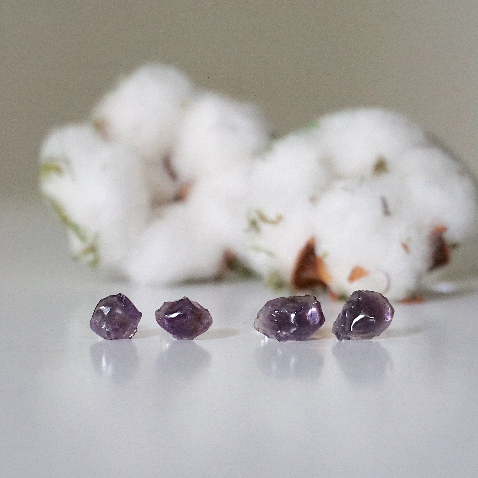 Two pairs of raw amethyst stud earrings showing natural variation in stone size, shape, and color, sterling silver posts
