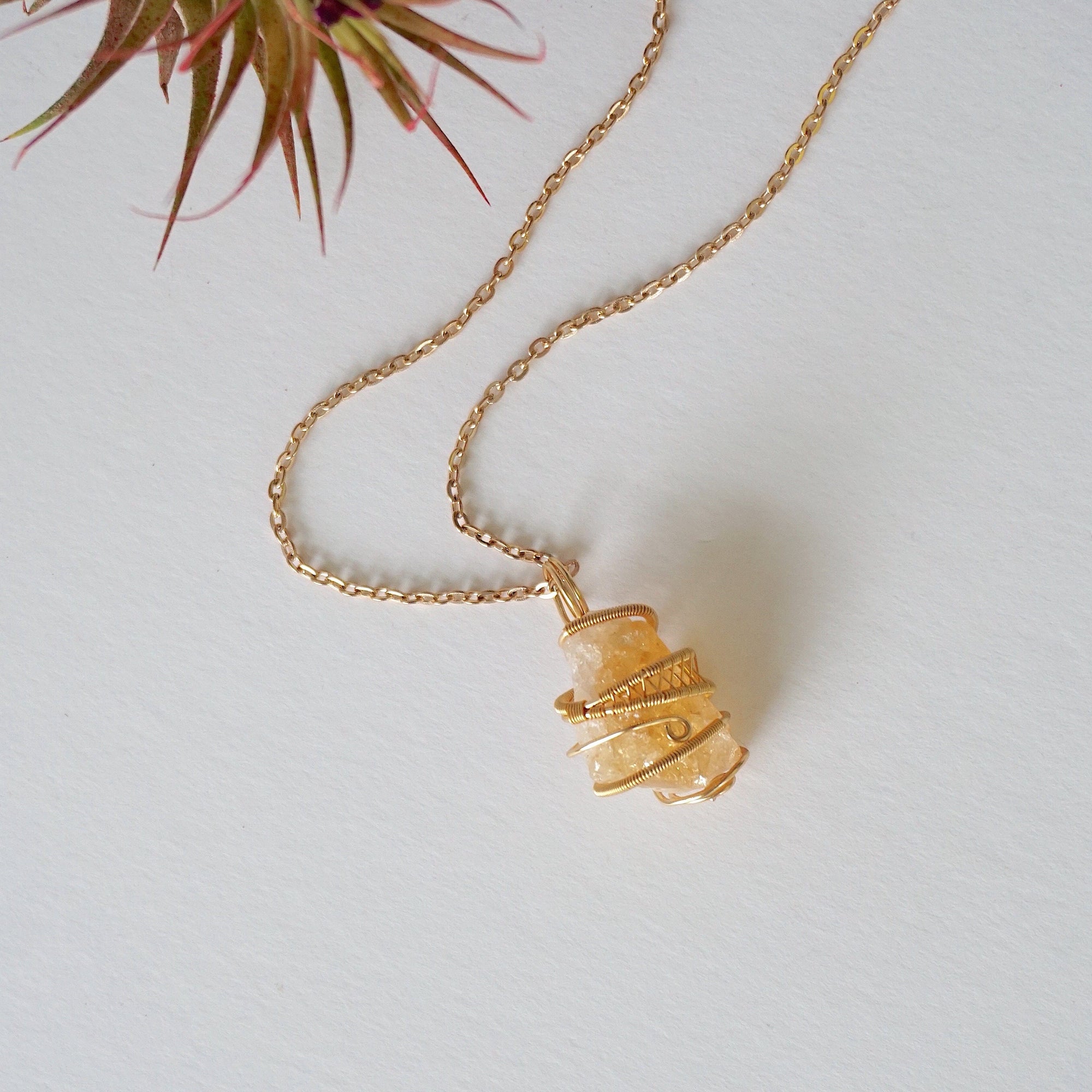 Raw citrine necklace laying flat in gold plated copper - handmade wire wrapped natural unpolished crystal pendant with chain full view November birthstone jewelry