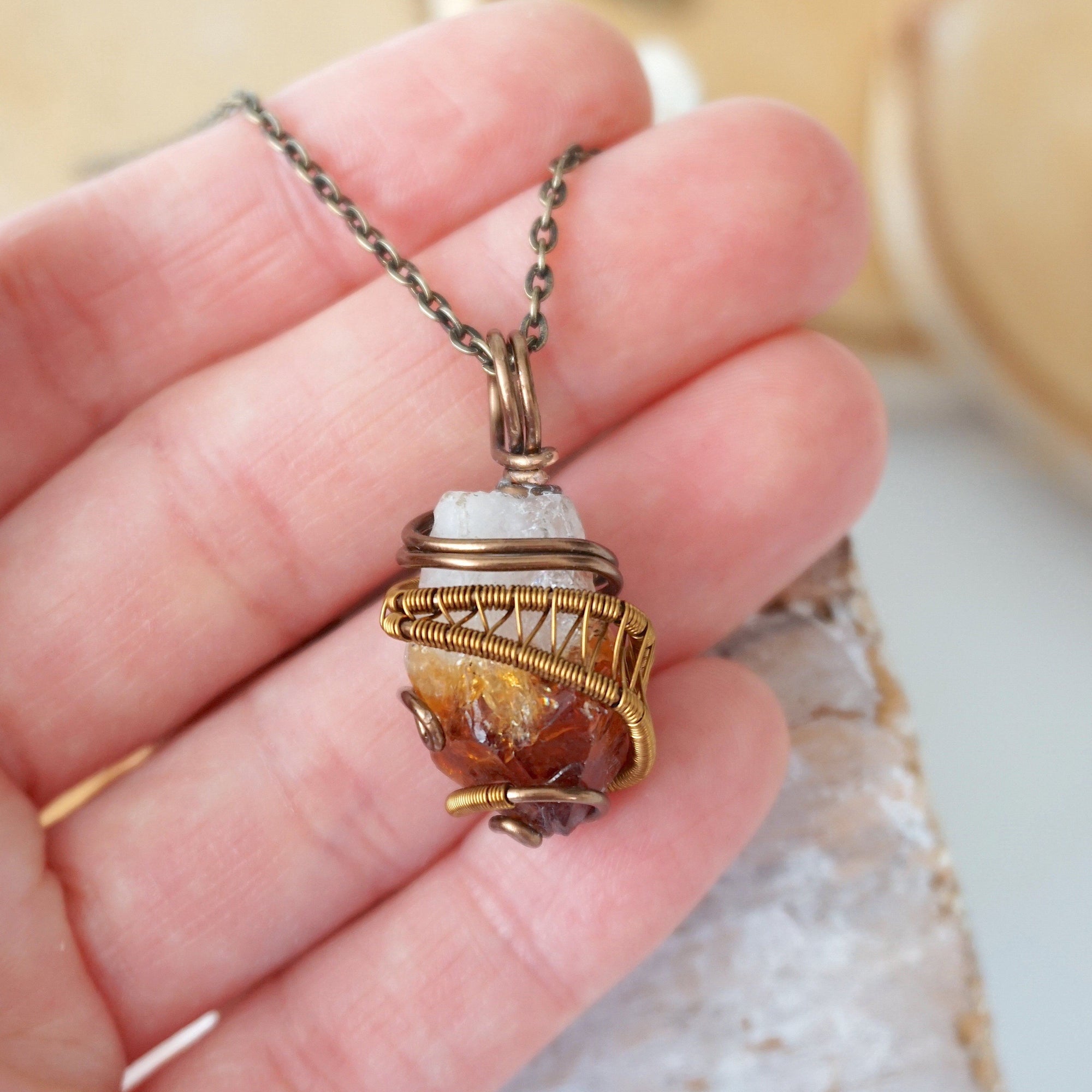 Raw citrine pendant held in hand showing size wire wrapped in antique bronze copper unisex necklace

