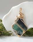 Back view of raw emerald pendant showing detailed artisan wire wrapping in 14k gold-filled wire.