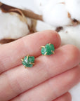 Natural raw emerald stud earrings in 14k gold vermeil shown in hand to display size and organic stone variation