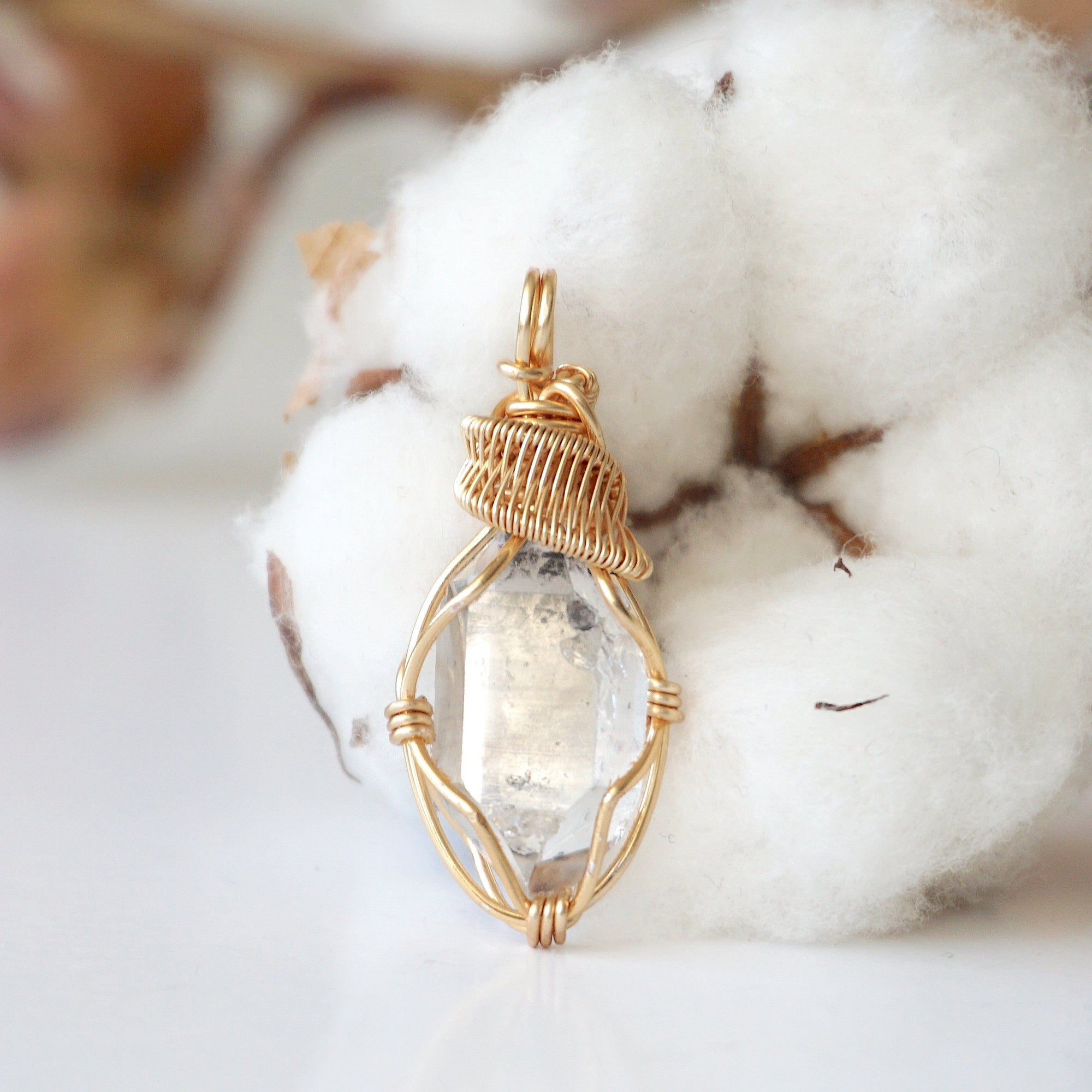 Detailed view of raw Herkimer diamond pendant with artisan wire wrapping in warm gold copper for women.