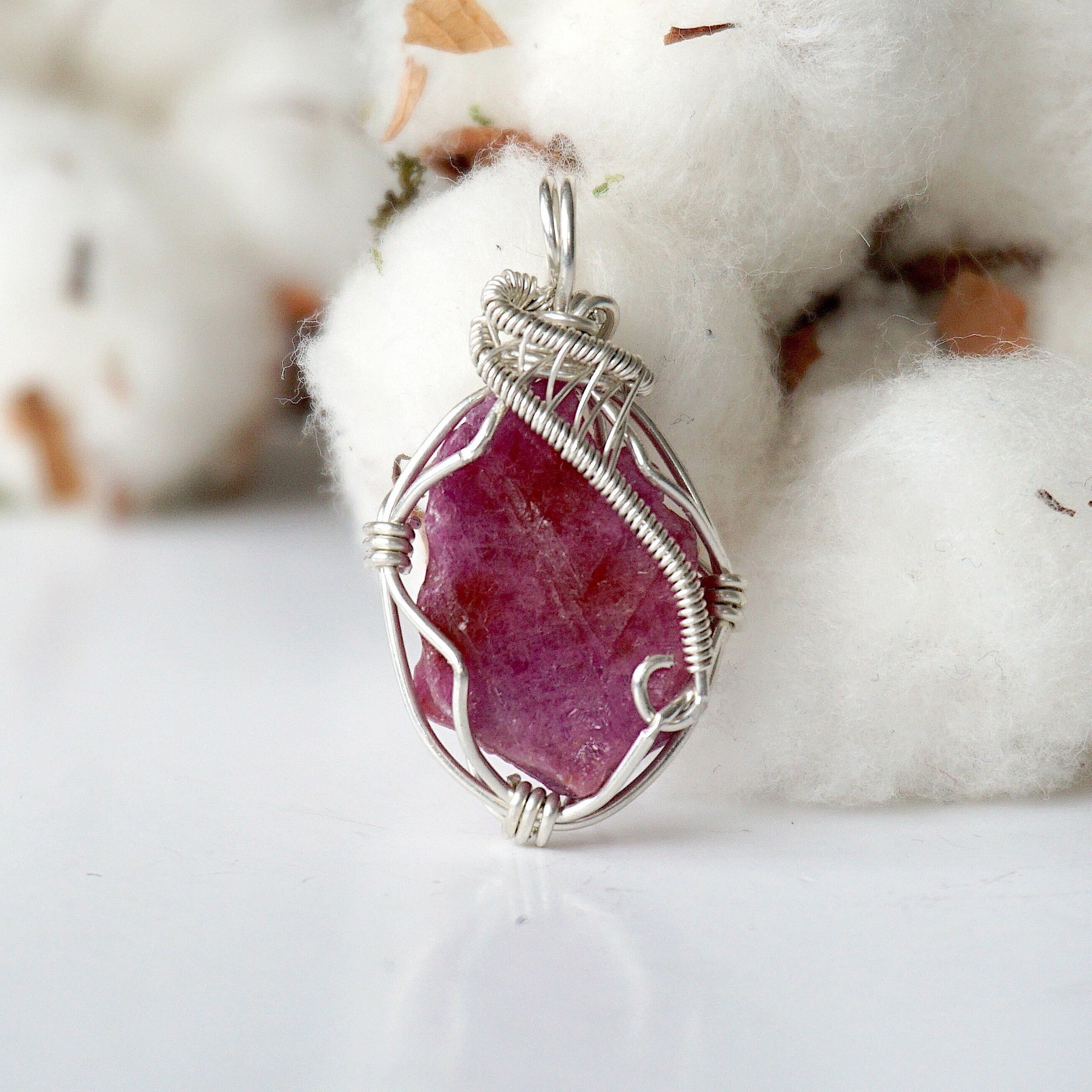 Detailed front side look at raw ruby pendant, natural pink ruby, sterling silver artisan wire wrapping
