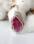 Detailed front side look at raw ruby pendant, natural pink ruby, sterling silver artisan wire wrapping