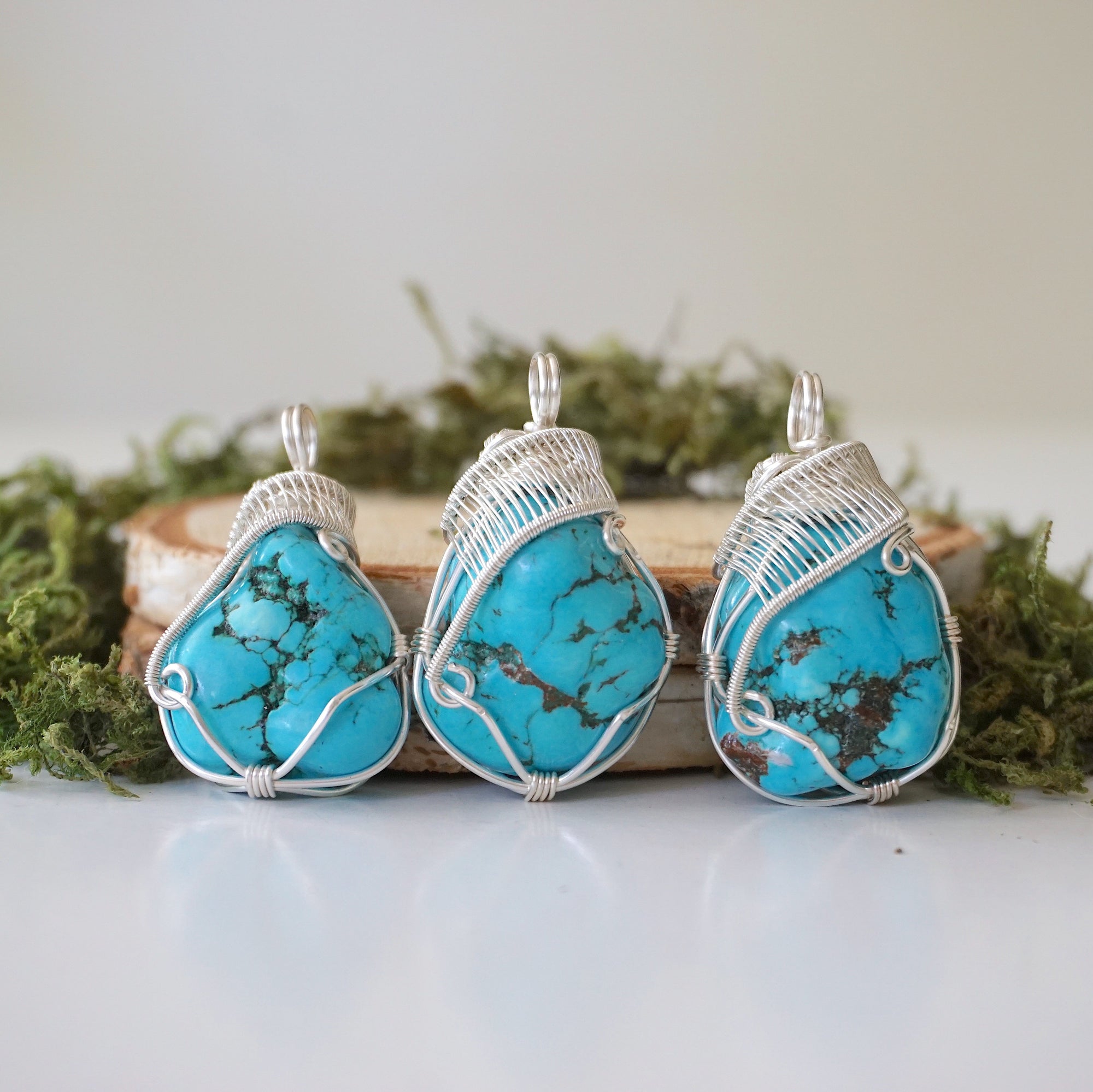 Three raw turquoise pendants showing natural stone color and shape variations