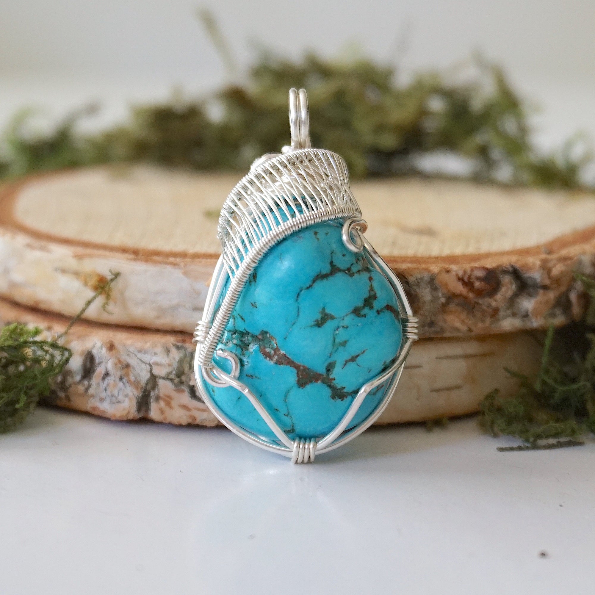 Front view raw turquoise pendant with detailed silver wire wrapping art