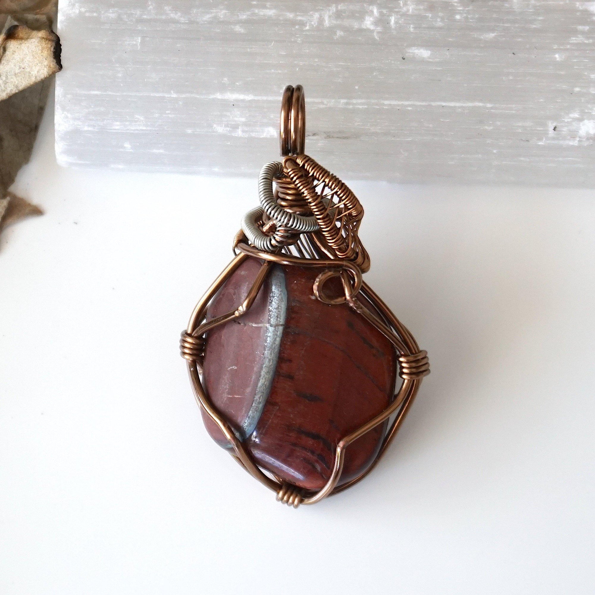 Back side angle view of natural red tiger's eye pendant, handcrafted jewelry by Designs by Nature Gems.