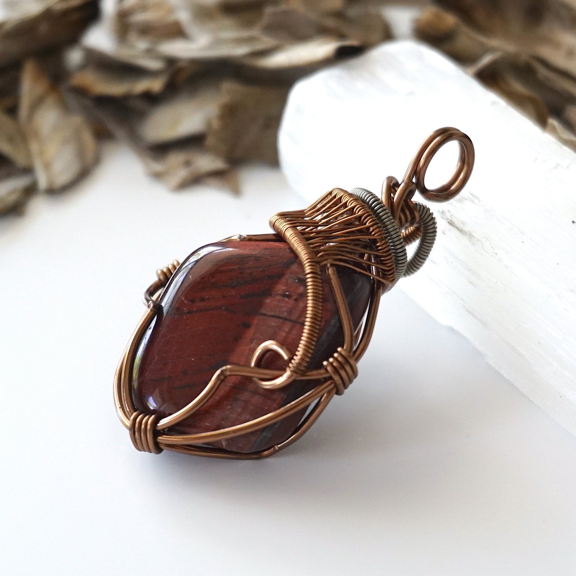 Left side angle detail of natural red tiger's eye pendant, artisan wire wrapped by Designs by Nature Gems.