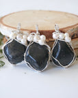 Three silver wire wrapped shungite and freshwater pearl pendants showing natural stone variation, artisan jewelry for women