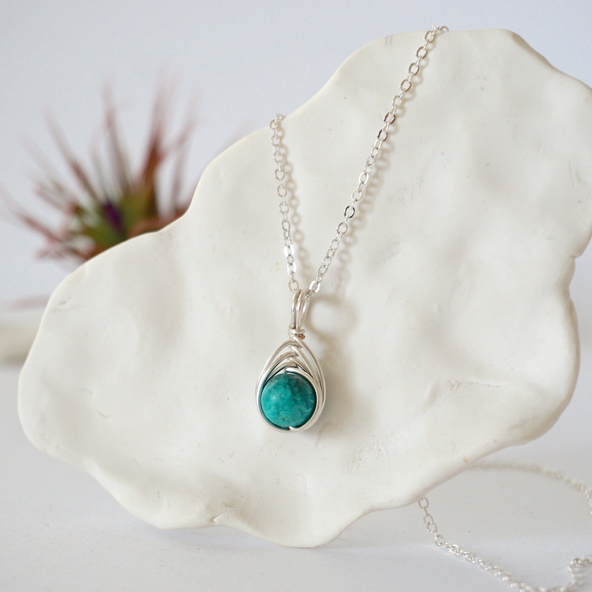 Left side angle of silver plated turquoise necklace showing wire wrap detail