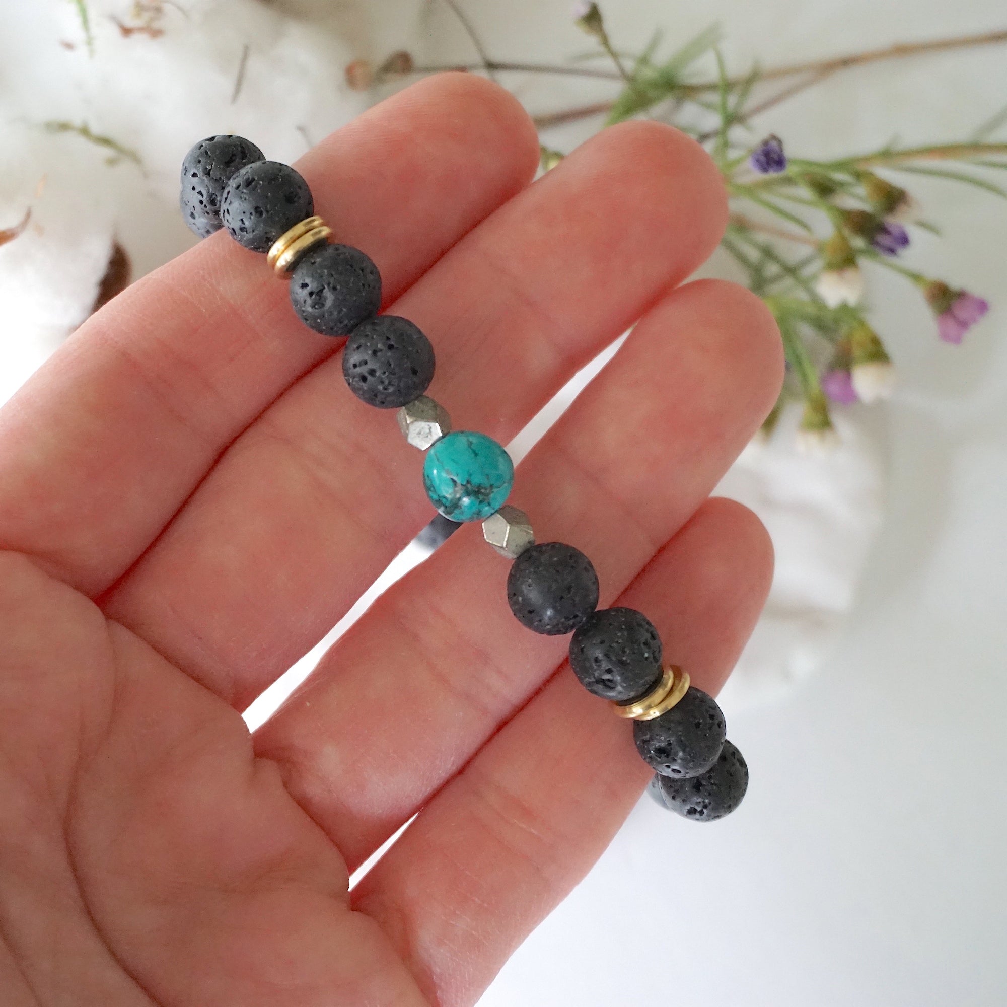 Turquoise lava bead mala bracelet with pyrite held in hand size view