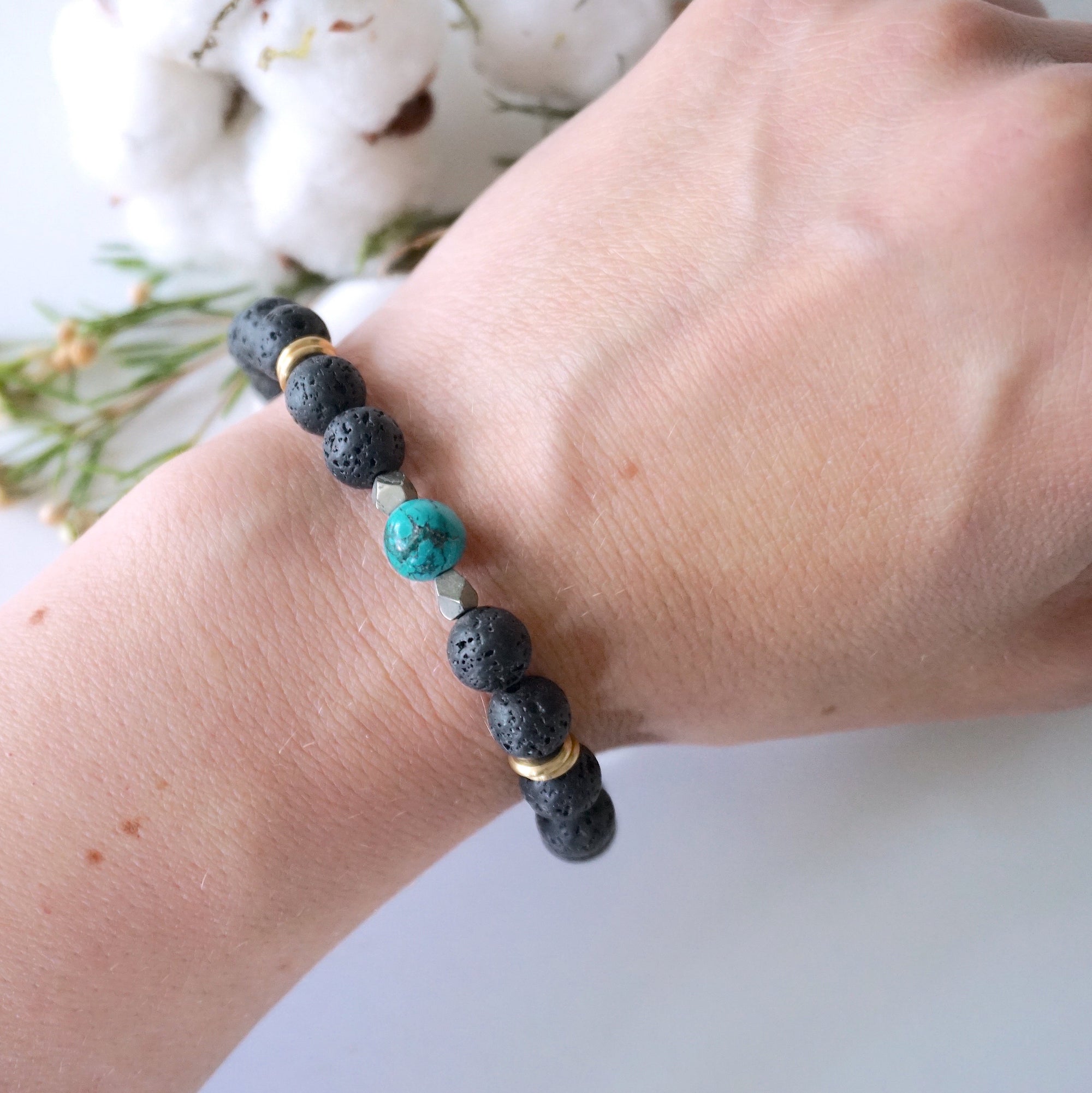 Turquoise lava bead mala bracelet with pyrite worn on woman's wrist lifestyle