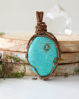 Back view of natural turquoise pendant revealing intricate wire work and artisan craftsmanship in antique bronze copper wire