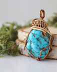 Side angle turquoise pendant showing wire wrap depth and mixed metal art