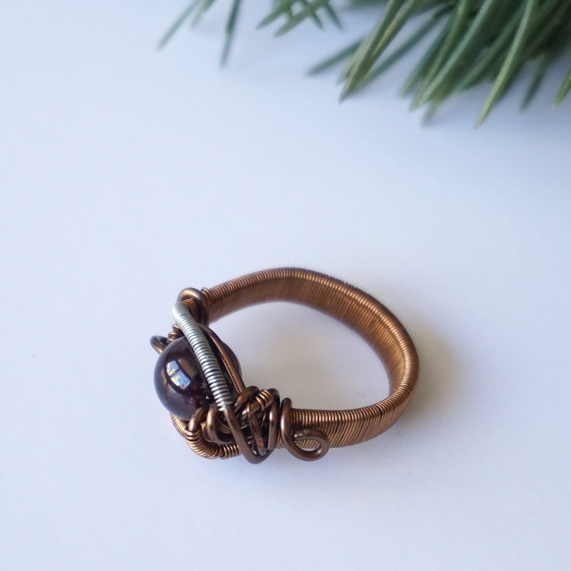 Bird’s-eye view of a wire wrapped garnet ring showing the centered garnet crystal and band width